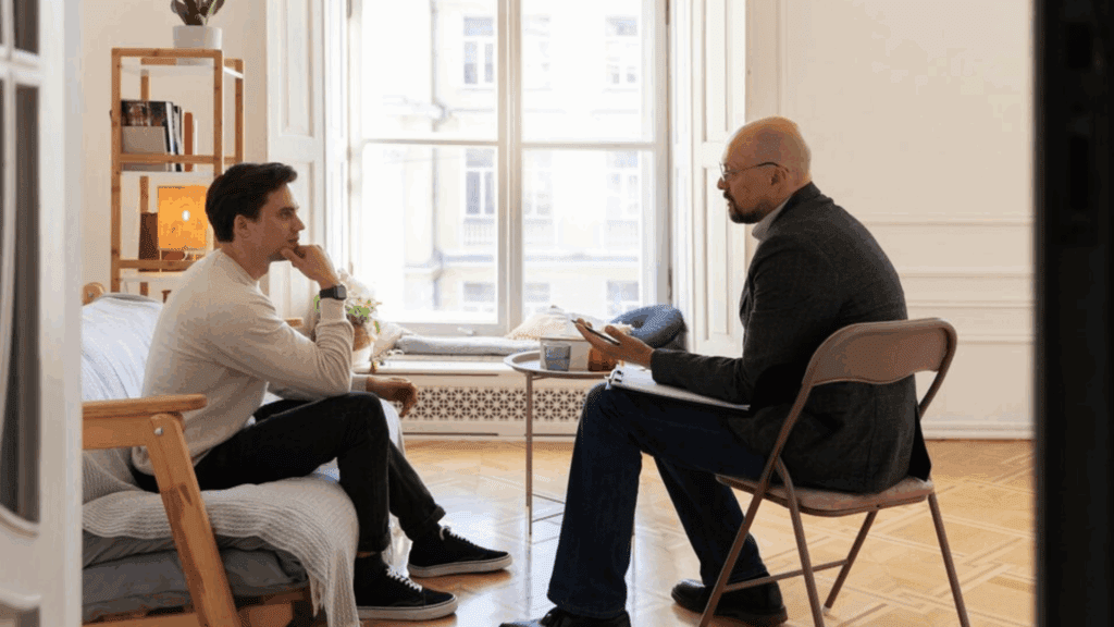 A gay man and a therapist during therapy, showing what typically takes place in a rehab for alcoholics.