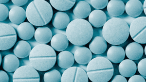 Blue tablets displayed on a background, exemplifying samples of the drug, roxicodone.