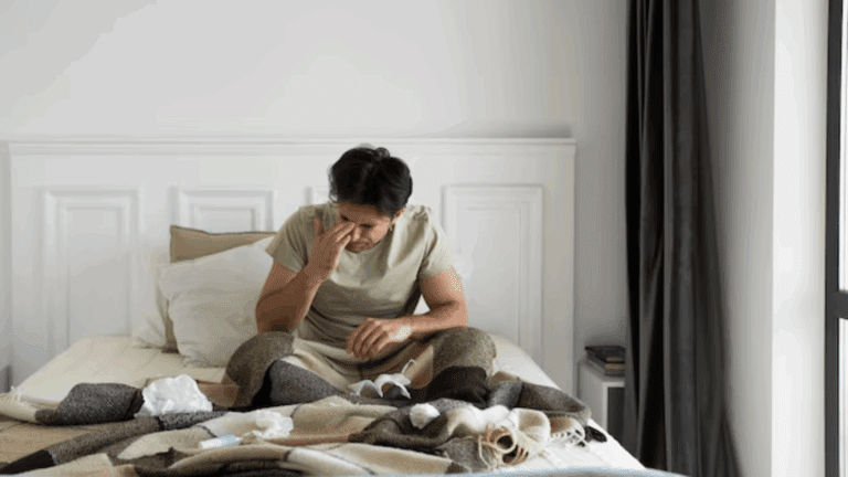 A gay person struggling to get up from bed.