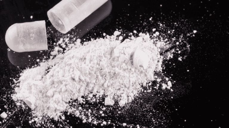 Powderized isotonitazene from a capsule on a black background.