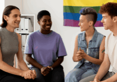 LGBTQ individuals sitting in a circle during a group therapy session, engaging in supportive conversation in a safe and welcoming environment.