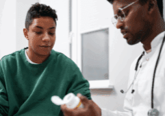 A medical doctor showing a gay person an addiction treatment medicine.