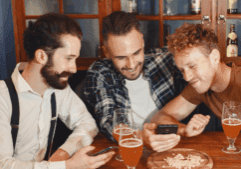 A group of gay friends, having fun while drinking beer in a bar who may have alcohol abuse.