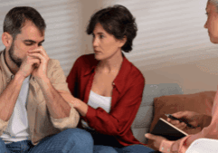 An image showing two ladies and a gay person sitting in a living room.