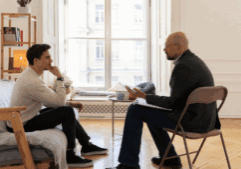 A gay man and a therapist during therapy, showing what typically takes place in a rehab for alcoholics.