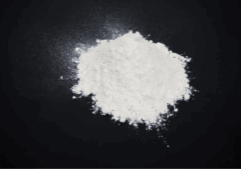 A close-up image of a white powder pile on a black surface, illustrating the drug cocaine or coke.