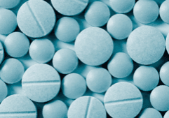 Blue tablets displayed on a background, exemplifying samples of the drug, roxicodone.