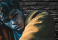 Young gay man leaning against a brick wall, appearing deep in thought—symbolizing the personal struggle of deciding to seek help for drug use.